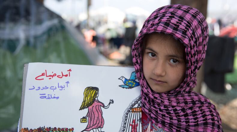 IDOMENI, GREECE - MARCH 18: Shaharzad Hassan holds up a drawing that she has made at the Idomeni refugee camp on the Greek Macedonia border on March 18, 2016 in Idomeni, Greece. The eight-year-old from Aleppo in Syria has been drawing a series of pictures depicting her families plight and their exodus to Europe only to be stranded at the Idomeni refugee camp. Many of the thousands of migrants stranded at the border camp are saying they are awaiting the outcome of the EU summit currently being held in Brussels. The decision by Macedonia to close its border to migrants last week has left thousands of people stranded at the Greek transit camp. The closure, following the lead taken by neighbouring countries, has effectively sealed the so-called western Balkan route, the main migration route that has been used by hundreds of thousands of migrants to reach countries in western Europe such as Germany. Humanitarian workers have described the conditions at the camp as desperate, which has been made much worse by recent spells of heavy rain. (Photo by Matt Cardy/Getty Images)