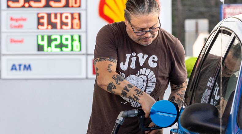 Roberto Zegarra pumps gas in Decatur on Wednesday, April 5, 2023. (Arvin Temkar / arvin.temkar@ajc.com)