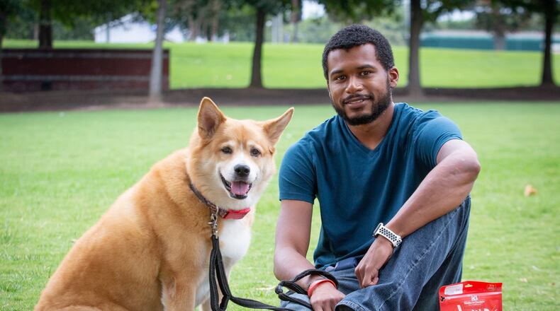 Pooch N Paws general manager Daniel Burton poses for a photograph with a friend's dog near his Suwanee store on August 10, 2020. STEVE SCHAEFER FOR THE ATLANTA JOURNAL-CONSTITUTION