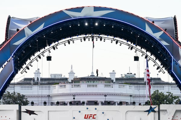 Security at the White House looks through a pair of binoculars during the UFC Fan Fest on the White House Ellipse ahead of Sunday’s fight on the South Lawn in Washington. (Allison Robbert/AP)