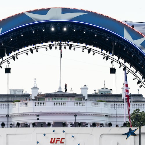 FILE - Security at the White House looks through a pair of binoculars during the UFC Fan Fest on the White House Ellipse ahead of Sunday's fight on the South Lawn, June 13, 2026, in Washington. (AP Photo/Allison Robbert, File)