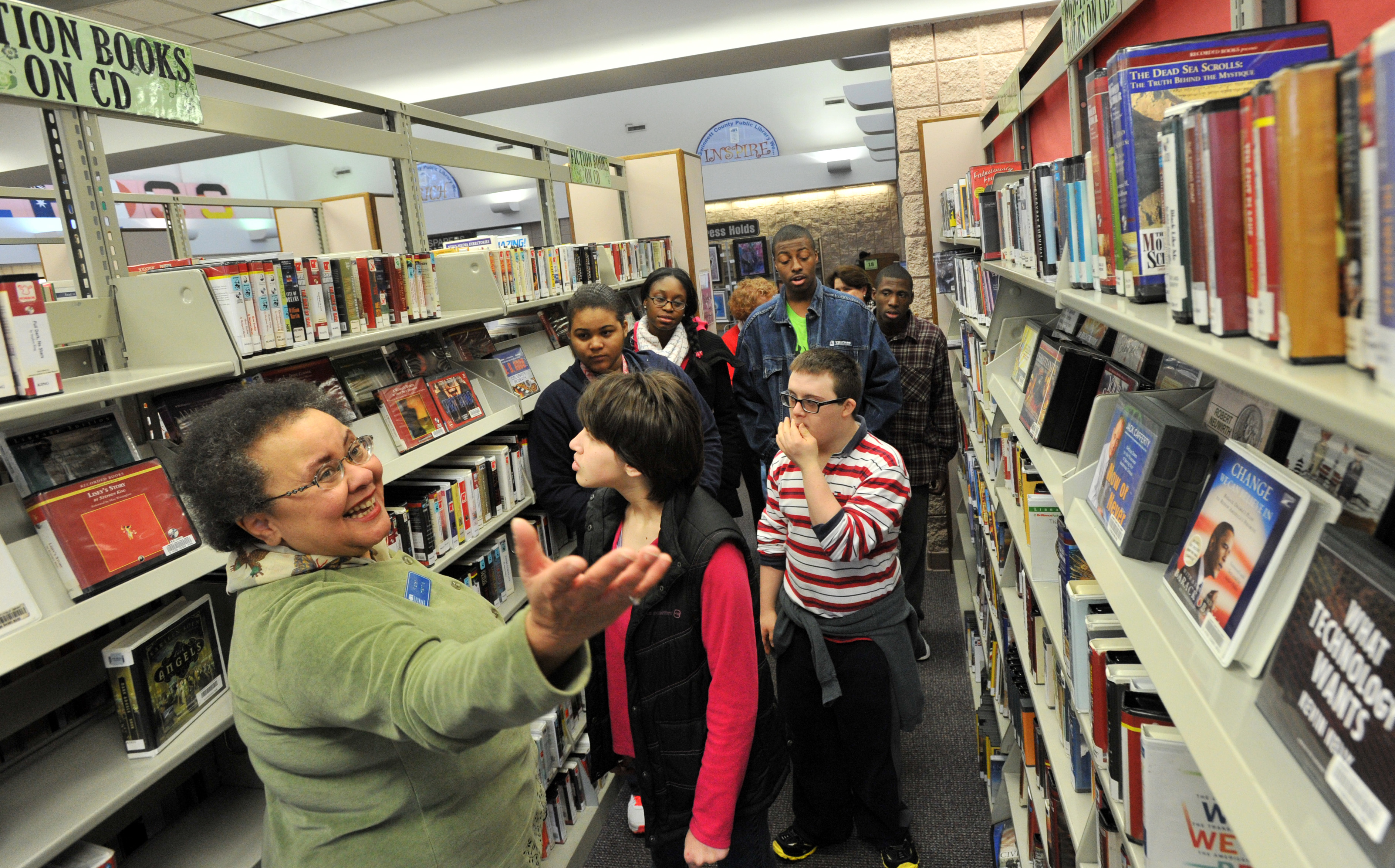 Karen Harris (left) leads a tour group at Gwinnett County Public Library. Two county library branches are offering special sensory hours for autistic children and their parents.
