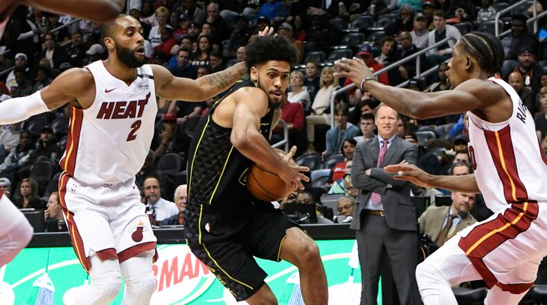 Atlanta Hawks guard Tyler Dorsey tries to get through the defense of Miami Heat guard Wayne Ellington (2) and forward Josh Richardson, right, during the first half of an NBA basketball game Wednesday, April 4, 2018, in Atlanta. (AP Photo/John Amis)