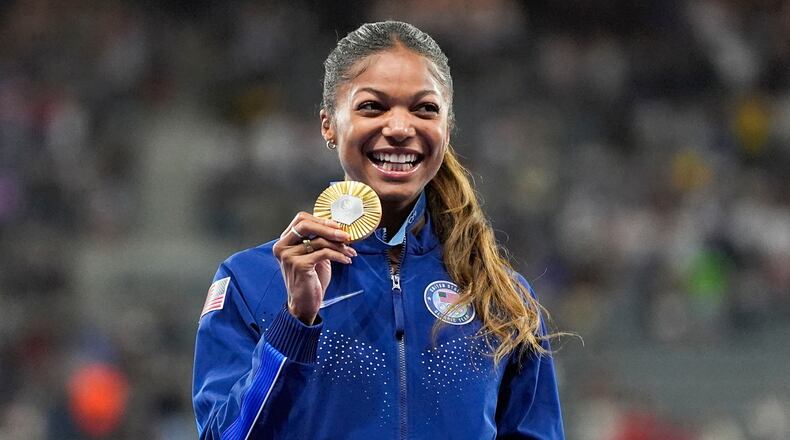 FILE - Gold medalist Gabby Thomas stands on the podium after the women's 200-meter at the 2024 Summer Olympics, Wednesday, Aug. 7, 2024, in Saint-Denis, France. (AP Photo/Matthias Schrade, File)