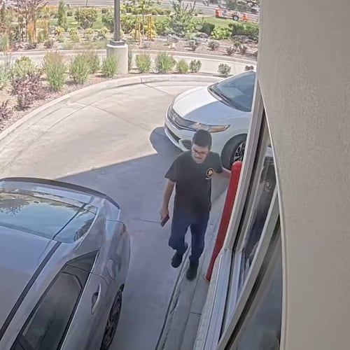 This image taken from video provided by the Twin Falls Police Department shows Chad Williams holding a gun and approaching a car in an In-N-Out drive-thru Saturday, Aug. 1, 2026, in Twin Falls, Idaho (Twin Falls Police Department via AP)