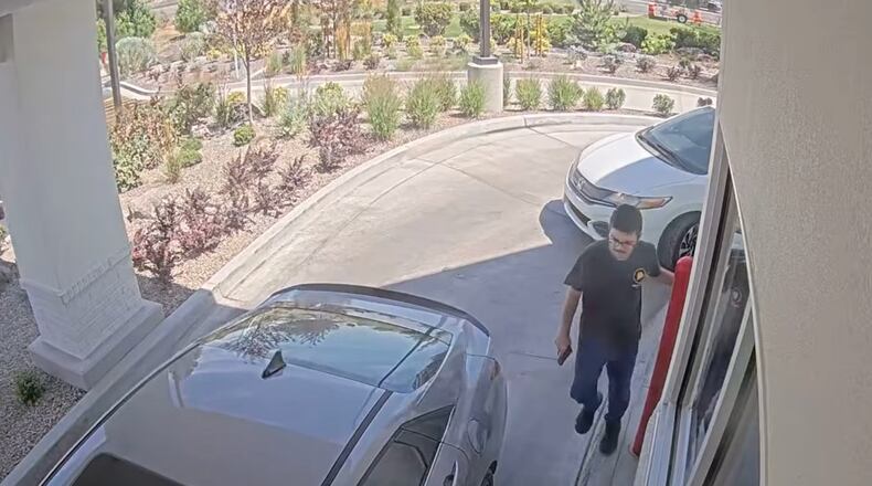 This image taken from video provided by the Twin Falls Police Department shows Chad Williams holding a gun and approaching a car in an In-N-Out drive-thru Saturday, Aug. 1, 2026, in Twin Falls, Idaho (Twin Falls Police Department via AP)
