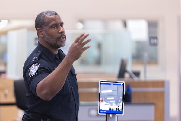 A U.S. Customs and Border Protection officer gestures travelers toward a new facial recognition technology system in customs at Hartsfield-Jackson's international terminal in Atlanta on Wednesday, June 25, 2025. (Arvin Temkar/AJC)