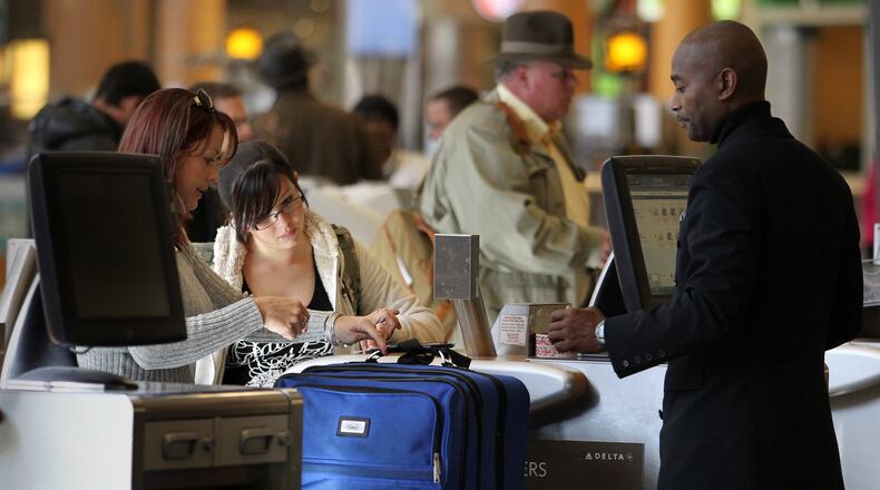 111711 Atlanta, Ga; Katrina Holland, left, and her daughter Sasha Graham, of Phoenix, talk with a Delta employee as they check in their luggage at the Delta check in counters at Hartsfield-Jackson International Airport Thursday morning in Atlanta, Ga., November 17, 2011. Holland and Graham checked in three bags at a charge of $85. Holland, who was visiting family in Atlanta, said they don't like the bag fees but only used Delta because of the good ticket deal they got on the internet. Delta charges passengers baggage fees to check luggage. Federal regulators think the flying public deserves more transparency upfront about the full price of tickets and fees. Some airlines are fighting the move. Jason Getz jgetz@ajc.com