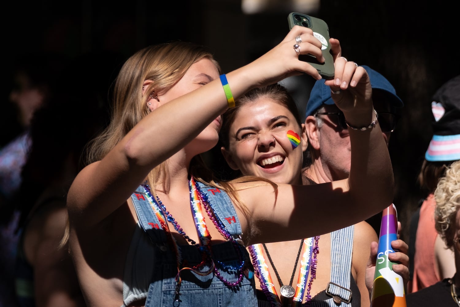 Lucia Gravel (left) takes a selfie with Katrina Zanbaka as they watch the Atlanta Pride Parade on Sunday, Oct. 12, 2025. (Ben Gray for the AJC)