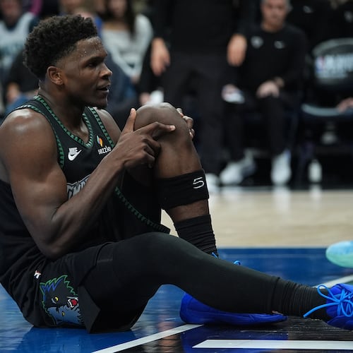 Minnesota Timberwolves guard Anthony Edwards grabs his knee after an injury during the first half of Game 4 of a first-round NBA basketball playoff series against the Denver Nuggets, Saturday, April 25, 2026, in Minneapolis. (AP Photo/Abbie Parr)