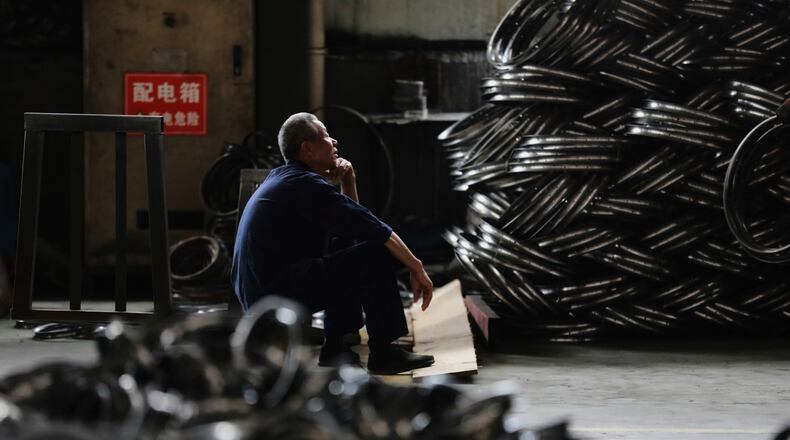FILE - A worker takes a rest at a factory making steel bike rims for export to U.S., in Hangzhou in east China's Zhejiang province, on Friday, April 11, 2025. (Chinatopix Via AP, File)