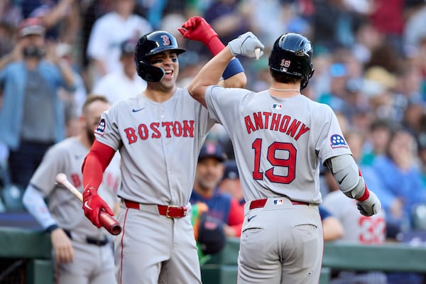 Boston Red Sox's Roman Anthony (19) is greeted by Marcelo Mayer, left, after hitting a solo home run off Seattle Mariners starting pitcher Logan Gilbert during the first inning of a baseball game Monday, June 16, 2025, in Seattle. (AP Photo/John Froschauer)