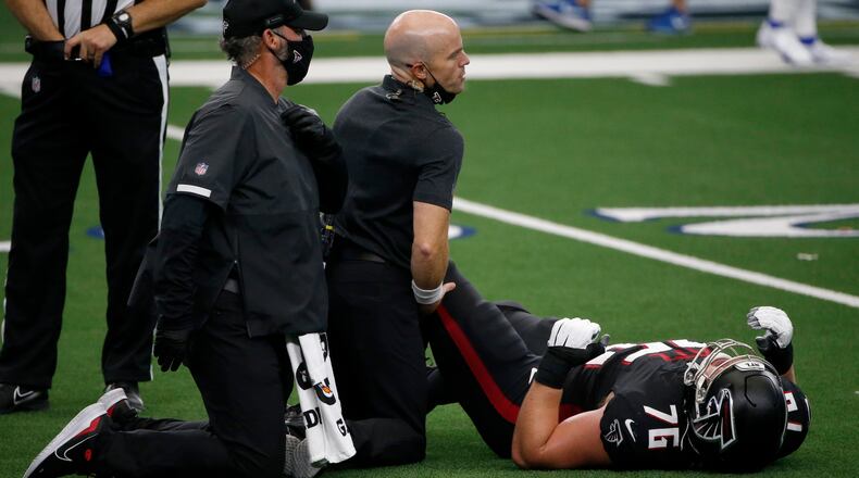 Atlanta Falcons offensive tackle Kaleb McGary (76) is attended to by team staff in the first half against the Dallas Cowboys in Arlington, Texas, Sunday, Sept. 20, 2020. (Michael Ainsworth/AP)
