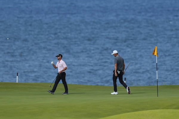 Li Haotong of China, right and Brian Harman of the United States walk on the 5th green during the third round of the British Open golf championship at the Royal Portrush Golf Club, Northern Ireland, Saturday, July 19, 2025. (AP Photo/Jon Super)