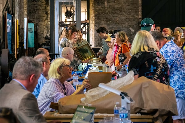 Appraisers inspect items brought in by attendees at the "Antiques Roadshow" in Savannah, GA, on April 29, 2025. (Justin Taylor for The Atlanta Journal-Constitution)