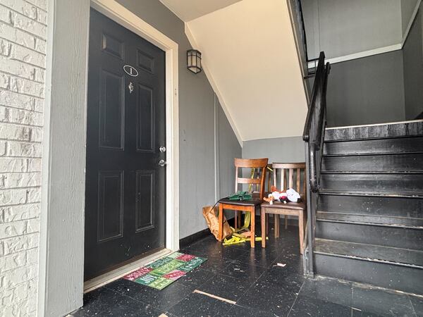 A holiday doormat, remnants of crime scene tape and several stuffed toys remain outside the DeKalb County apartment Monday. David Aaro / AJC