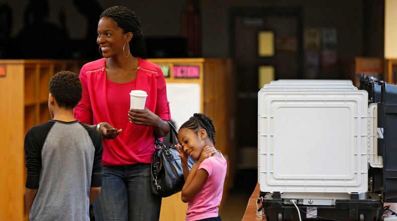 Stacie Dukes brought her children, Kaleb (left) and Aunjere with her. Voters cast their ballots at Mary Mcleod Bethune Middle School on July 14, 2015. BOB ANDRES / BANDRES@AJC.COM