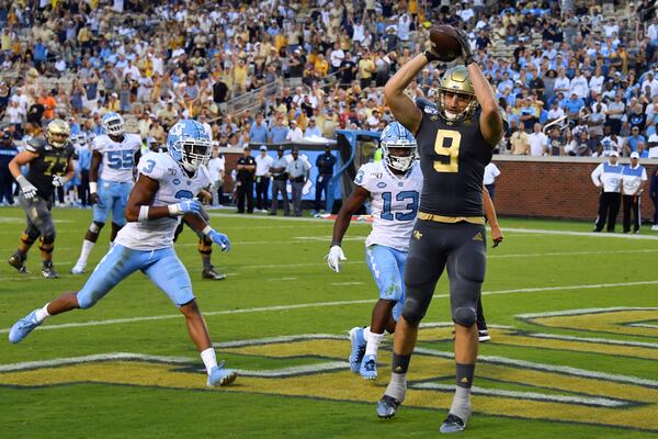 Georgia Tech tight end Tyler Davis (9) scores a touchdown with North Carolina linebacker Dominique Ross (3) and defensive back Don Chapman defending during the second half of an NCAA college football game against North Carolina, Saturday, Oct. 5, 2019, in Atlanta. North Carolina won 38-22. (Special-John Amis)