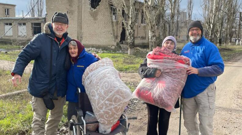 Atlantan Ken Ward (right) stands with three displaced Ukrainians in Kherson, Ukraine. Courtesy of HelpingUkraine.U.S.