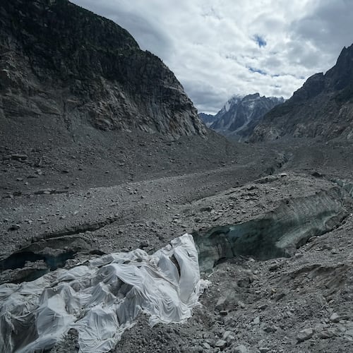 Tarpaulins cover the ice cave of the 'Mer de Glace' glacier to prevent it from melting, at the Montenvers station in Chamonix, France, Saturday, Sept. 5, 2026. (AP Photo/Laurent Cipriani)