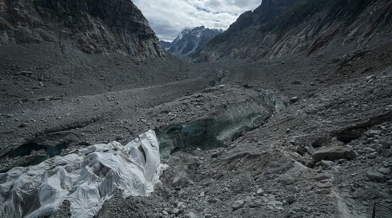 Tarpaulins cover the ice cave of the 'Mer de Glace' glacier to prevent it from melting, at the Montenvers station in Chamonix, France, Saturday, Sept. 5, 2026. (AP Photo/Laurent Cipriani)