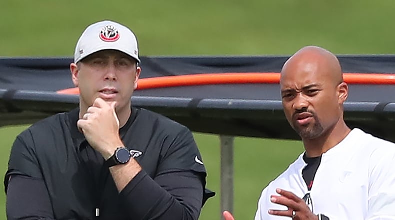 Falcons head coach Arthur Smith (left) and general manager Terry Fontenot confer during team practice at minicamp Wednesday, June 10, 2021, in Flowery Branch. (Curtis Compton / Curtis.Compton@ajc.com)