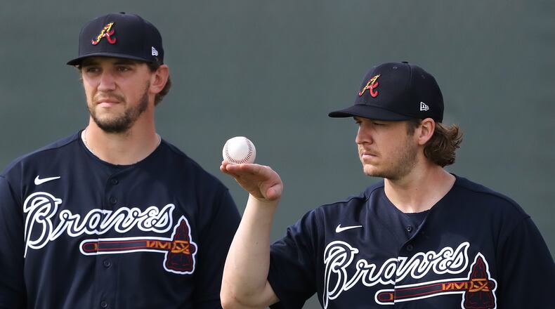 Braves pitcher Jacob Webb (right) balances a baseball while loosening up his arm with Patrick Weigel during spring training on Friday, Feb. 14, 2020, in North Port. Curtis Compton ccompton@ajc.com