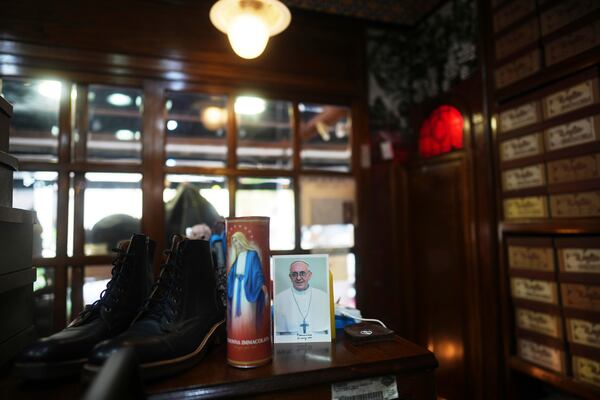 A photograph of the late Pope Francis is displayed at the Muglia shoe store where the future pontiff, known as Jorge Bergoglio, used to buy his shoes in the Flores neighborhood where he grew up in Buenos Aires, Argentina, Thursday, April 24, 2025. (AP Photo/Natacha Pisarenko)