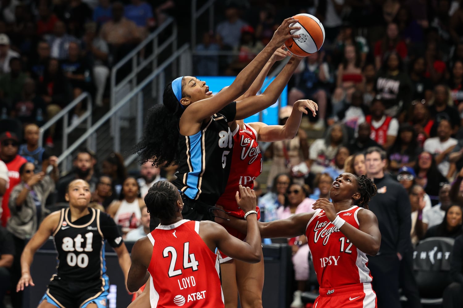 Atlanta Dream forward Angel Reese, center, grabs an offensive rebound against Las Vegas Aces guard Jewell Loyd (24) and guard Chelsea Gray (12) during the second half of a WNBA game at State Farm Arena on Sunday, May 17, 2026, in Atlanta. (Colin Hubbard for the AJC) 