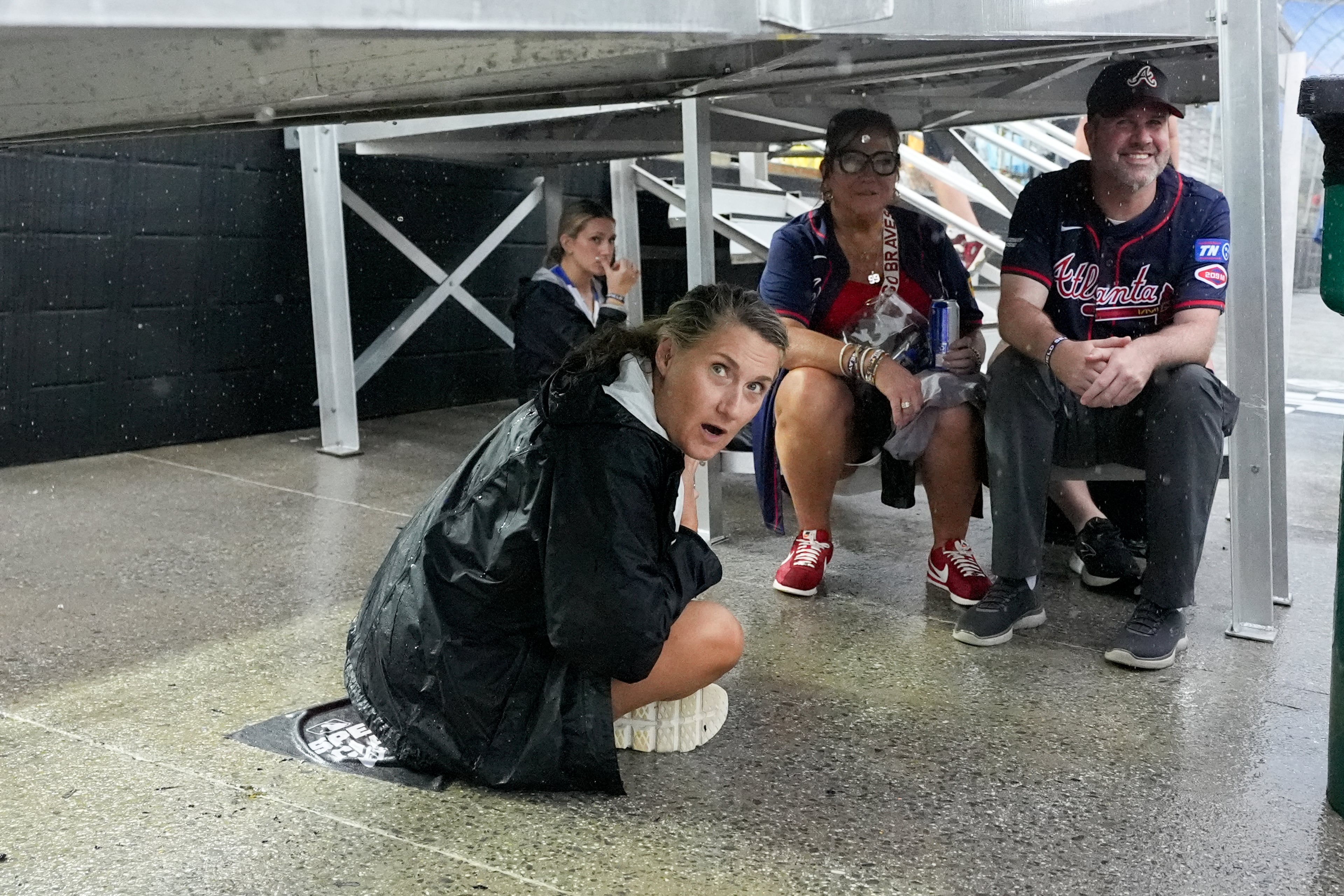 Fans wait out a rain delay at the MLB Speedway Classic baseball game between the Atlanta Braves and the Cincinnati Reds at Bristol Motor Speedway in Bristol, Tenn., Saturday, Aug. 2, 2025. (AP Photo/George Walker IV)