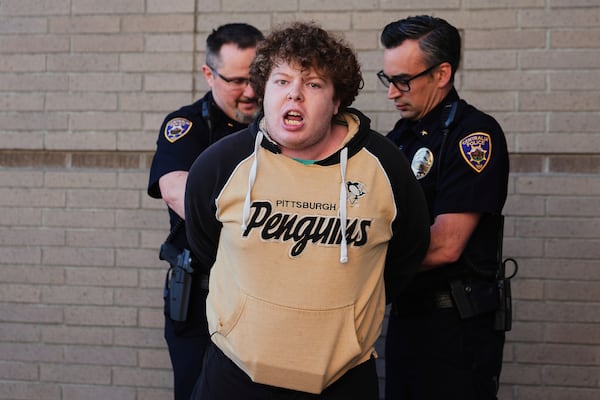 A protester is arrested by Centralia police officers at a town hall event with Rep. Marie Gluesenkamp Perez, D-Wash., at Centralia College, Tuesday, April 22, 2025, in Centralia, Wash. (AP Photo/Lindsey Wasson)