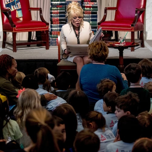 FILE - Dolly Parton reads her book "Coat of Many Colors," at the Library of Congress in Washington on Feb. 27, 2018. (AP Photo/Andrew Harnik, File)