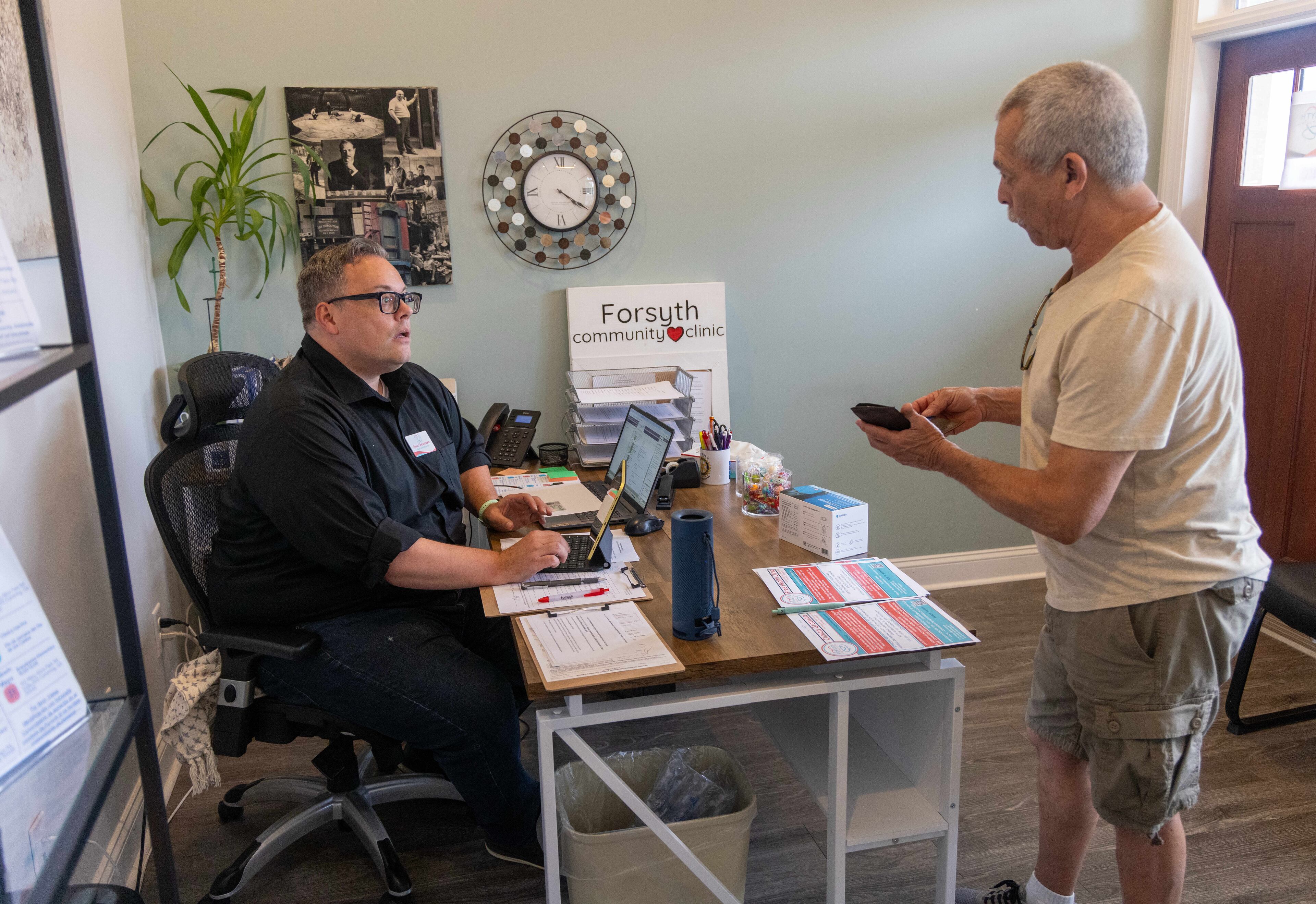 Forsyth Community Clinic Executive Director Evan Shoemake (left) takes Eddy Pineda's information during a visit. (Phil Skinner for the AJC)