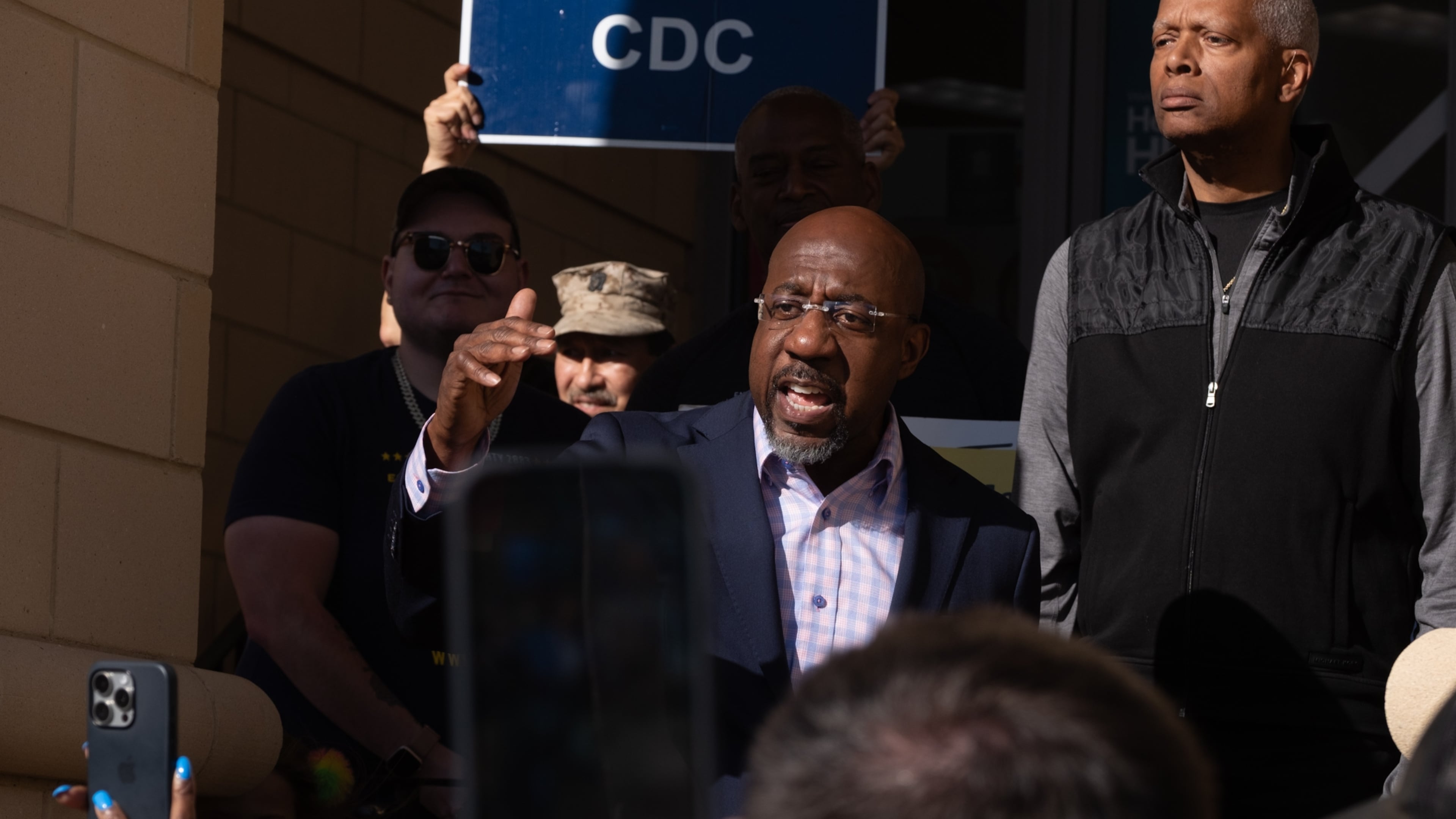 Sen. Raphael Warnock and Rep. Hank Johnson speak to a crowd in support of the Centers For Disease Control and Prevention across the street from their headquarters on Tuesday, April 15, 2025, in Atlanta. (Ben Gray for the AJC)