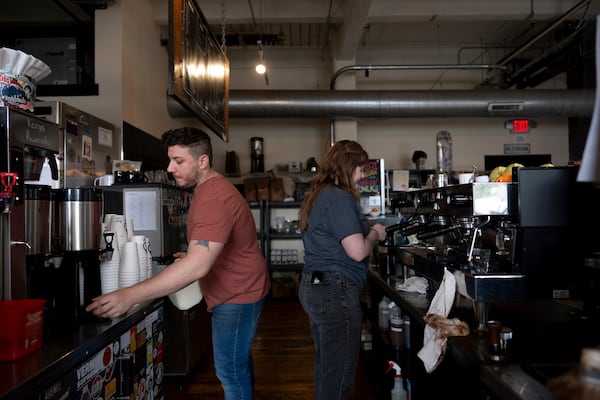 Anderson Miller, left, and Claire Terrelli, right, make coffee at Fuego Coffee Roasters in Rochester, N.Y., Saturday, March 22, 2025. (Max Conway via AP)