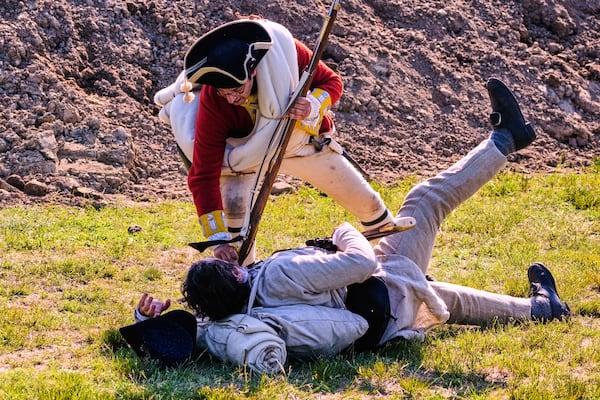A Colonial soldier is knocked to the ground by a British soldier during a reenactment in celebration of the 250th anniversary of the Battle of Bunker Hill, Saturday, June 21, 2025, in Gloucester, Mass. (AP Photo/Charles Krupa)