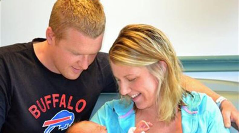 In this photo taken Aug 11, 2015, and provided by Mercy Hospital of Buffalo, Stephanie and Jason Brueggeman pose with their newborn daughter at the hospital in Buffalo, N.Y. Jason planned to drop his wife at work and then head to work himself until waking to find they were snowed in by a record storm that went on for days last November, piling some 7 feet of snow outside their town of Lancaster home. Nine months later, they've welcomed Grace Elizabeth, who is part of a baby boom being seen at the city hospital that serves the towns hardest hit by the "Snowvember" storm. (Melanie Griffis/Mercy Hospital of Buffalo, via AP)