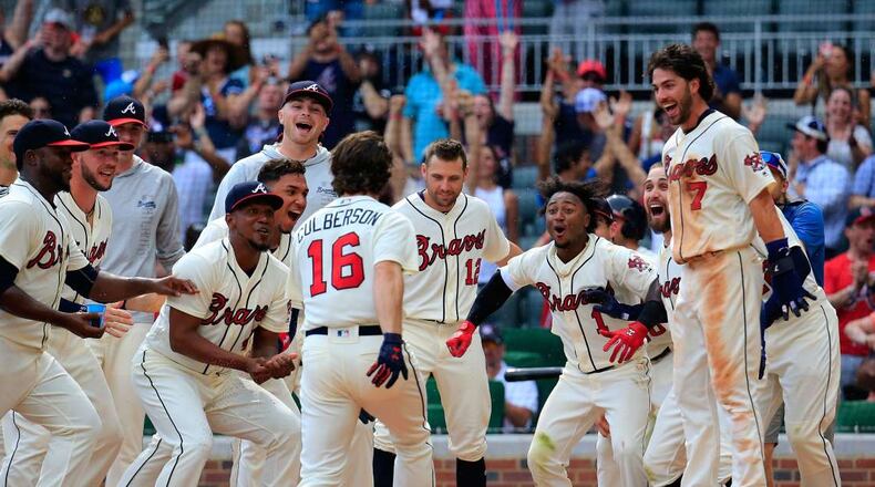 Teammates wait for Charlie Culberson to cross home plate on one of his two walk-off homers last week. (AP photo)