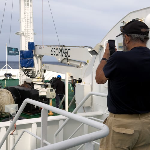 A passenger on the the hantavirus-stricken cruise ship, MV Hondius, takes a photo of the ship's weighing anchor in Praia, during the voyage to Spain's port of Tenerife, May 6, 2026. (AP Photo)