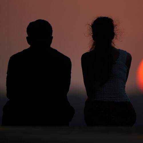 People watch the setting sun at the end of a hot summer day, Sunday, July 26, 2026, in Kansas City, Mo. (AP Photo/Charlie Riedel)