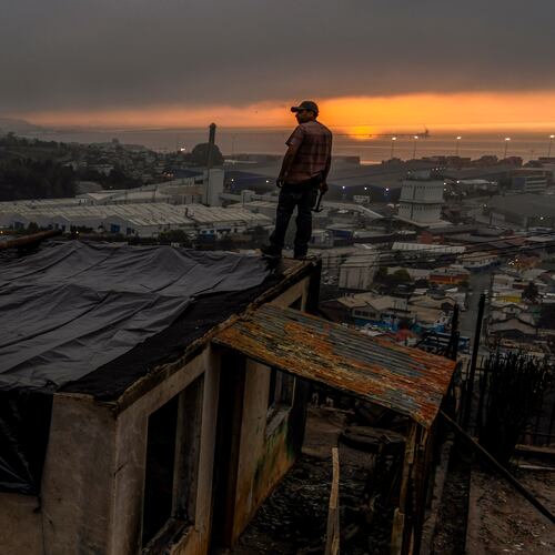 Jonathan Escalona stands over his house damaged by wildfires in Lirquen, Chile, Tuesday, Jan. 20, 2026. (AP Photo/Javier Torres)
