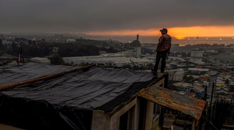 Jonathan Escalona stands over his house damaged by wildfires in Lirquen, Chile, Tuesday, Jan. 20, 2026. (AP Photo/Javier Torres)