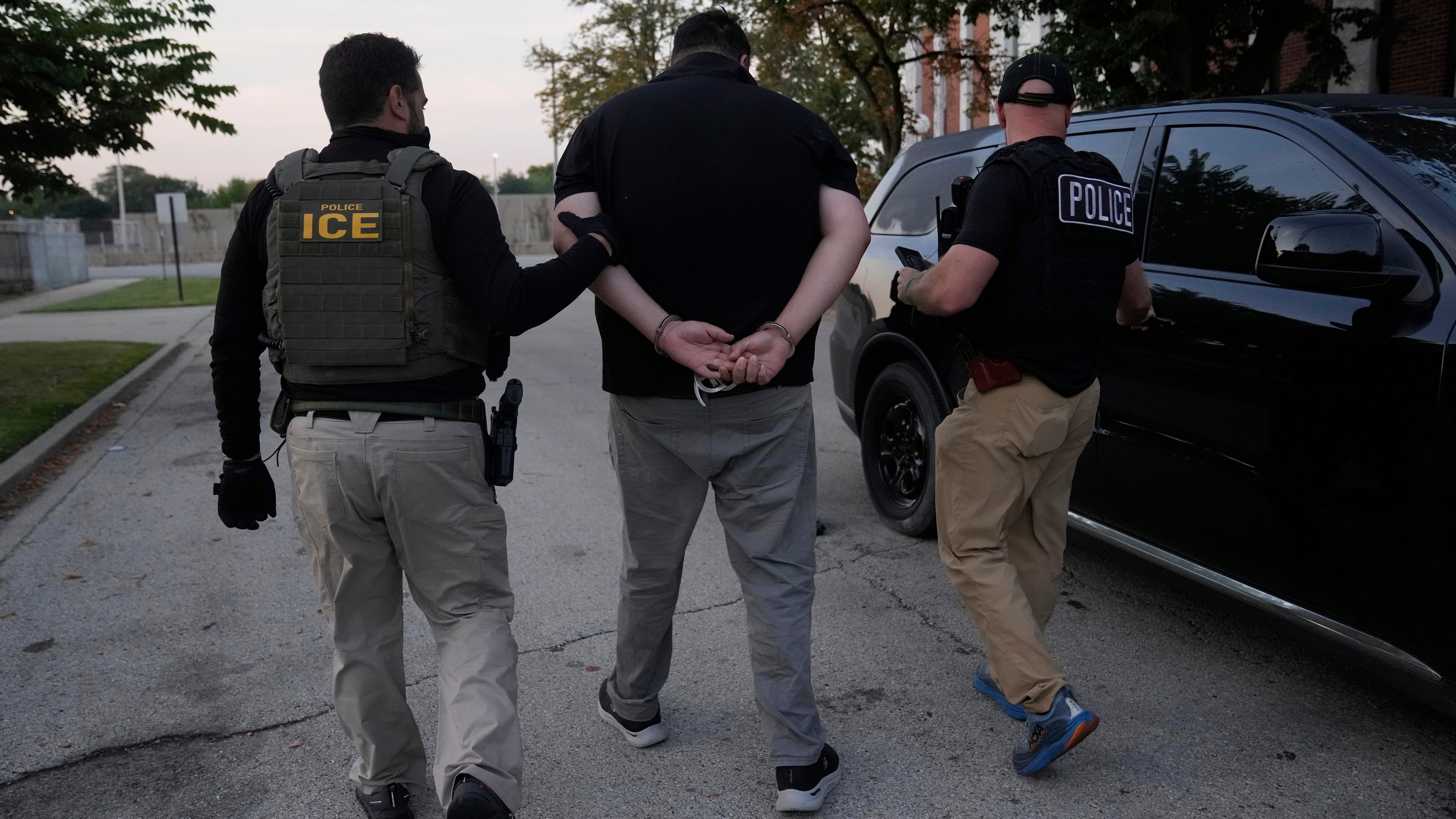 U.S. Immigration and Customs Enforcement agents make an arrest during an early morning operation in Park Ridge, Ill., Friday, Sept. 19, 2025. (AP Photo/Erin Hooley)