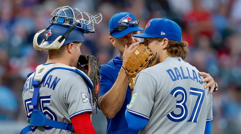 Toronto Blue Jays pitching coach Pete Walker, center, speaks with pitcher Chad Dallas (37) and catcher Tyler Heineman (55) during the third inning of a baseball game against the Atlanta Braves, Thursday, June 4, 2026, in Atlanta. (AP Photo/Erik S. Lesser)