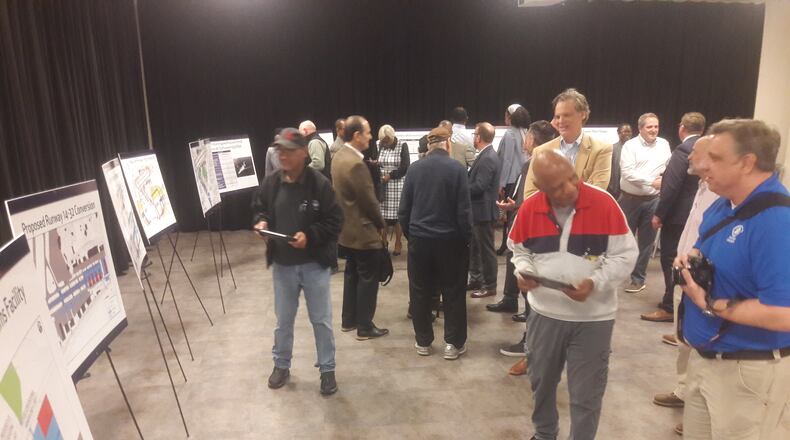 Consultants and stakeholders at Fulton County Executive Airport look over plans to lengthen the main runway and replace the crosswind runway with hangars at a public meeting Feb. 16, 2023,