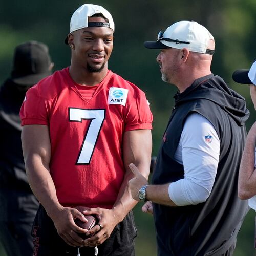 Atlanta Falcons running back Bijan Robinson (7) speak to a coach during a Atlanta Falcons training camp, Monday, Aug. 3, 2026, in Flowery Branch, Ga. (AP Photo/Mike Stewart)