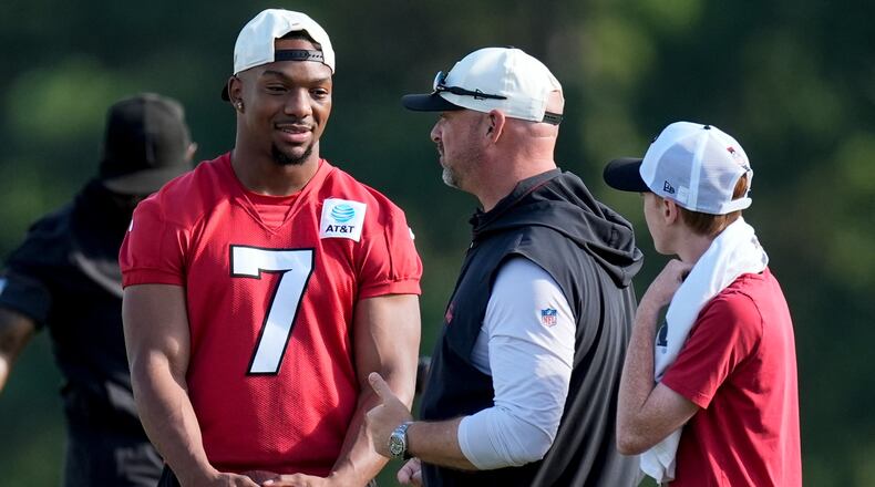 Atlanta Falcons running back Bijan Robinson (7) speak to a coach during a Atlanta Falcons training camp, Monday, Aug. 3, 2026, in Flowery Branch, Ga. (AP Photo/Mike Stewart)