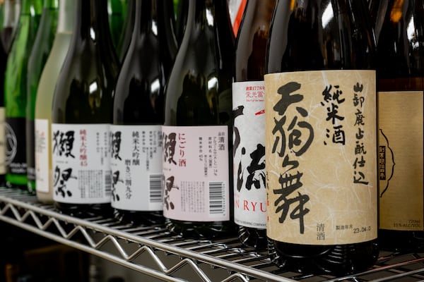 Bottles of sake sit in a special storage area at Brush Sushi. On the restaurant's menu, Allen has created a helpful chart that illustrates different sake flavor profiles. (Jason Allen/Atlanta Journal-Constitution)