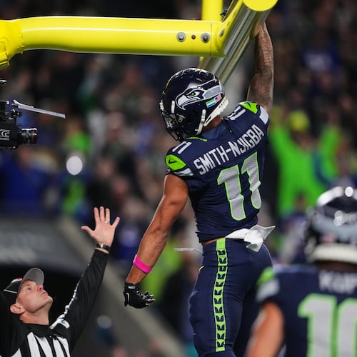 Seattle Seahawks wide receiver Jaxon Smith-Njigba (11) celebrates his touchdown catch as an official signals and looks on in the first half of an NFL football game Monday, Oct. 20, 2025, in Seattle. (AP Photo/Lindsey Wasson)