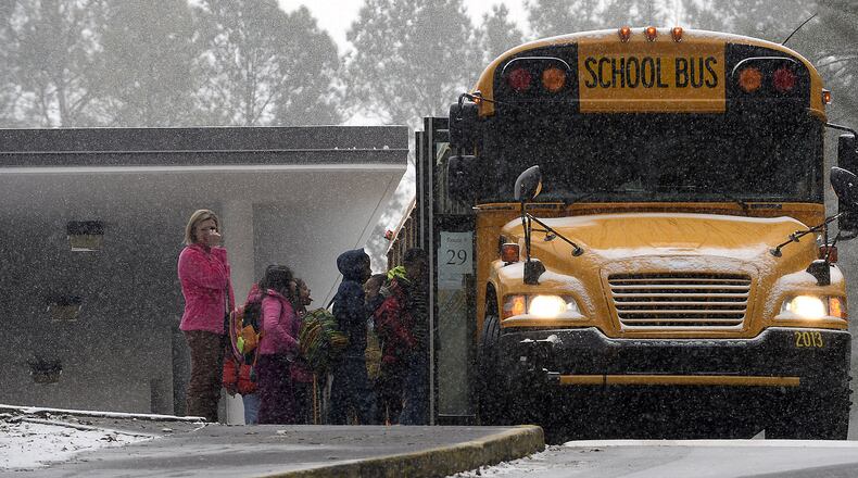 Sagamore Hills Elementary School students board a DeKalb County school bus for early dismissal as a major winter storm dumps 1 to 3 inches of snow on the metro Atlanta area, Tuesday, Jan. 28, 2014. David Tulis / AJC Special